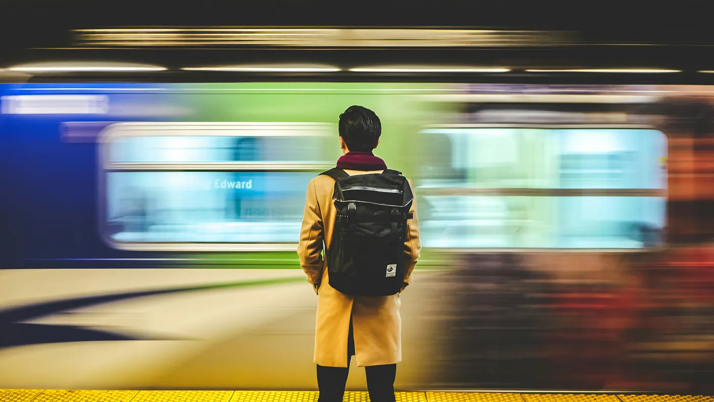 Person waiting on a subway platform as a train passes